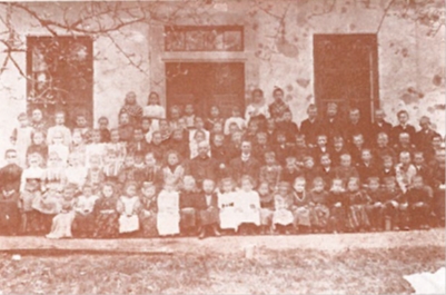 Učitelj in veroučitelj z učenci pred šolo, pred 1914